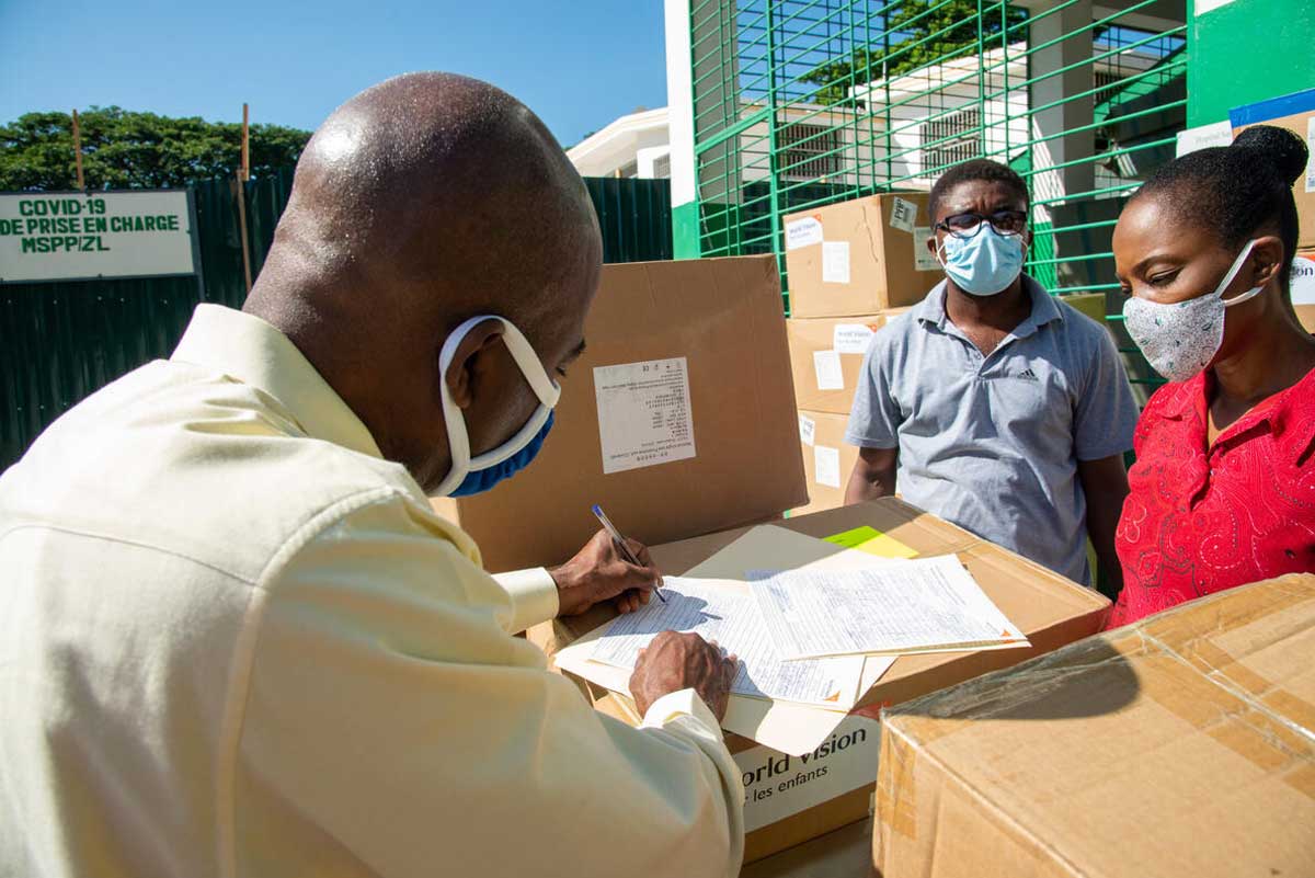 Un représentant portant un masque examine les fournitures médicales livrées à l’hôpital Sainte Thérèse en Haïti par Vision Mondiale Haïti.