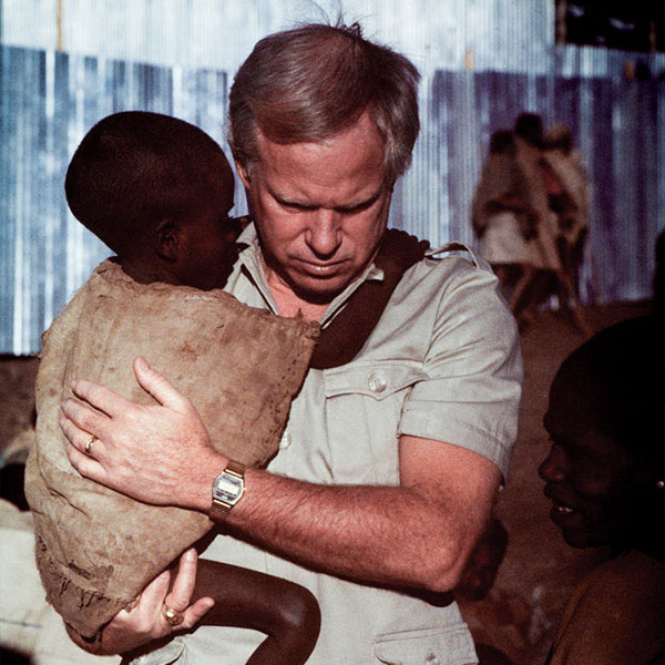 Un bénévole pour la charité chrétienne World Vision tient un enfant éthiopien dans ses bras.