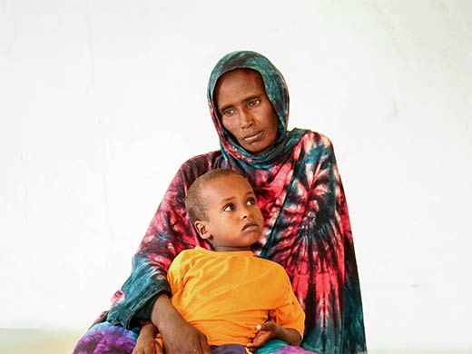 Dans une zone rurale de Somalie, une mère tient son enfant contre elle.