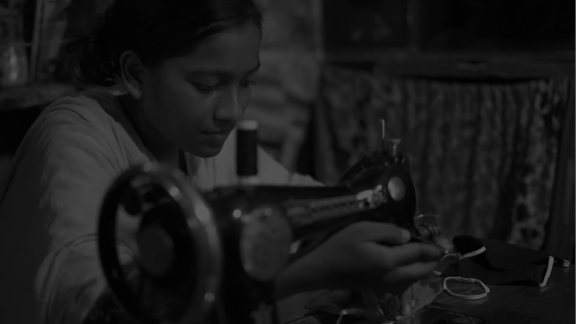 A young woman working with a traditional sewing machine.