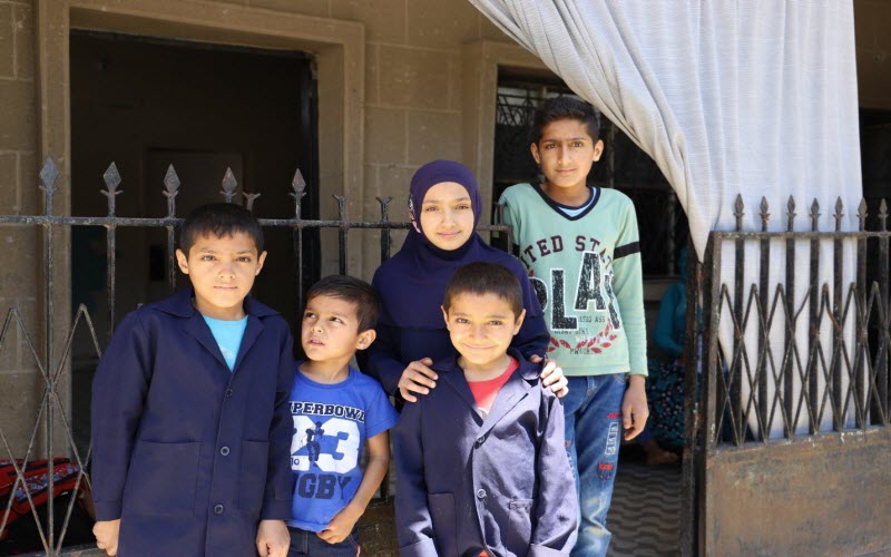 Cinq frères et sœurs, réfugiés syriens, se tiennent devant leur maison au Liban.
