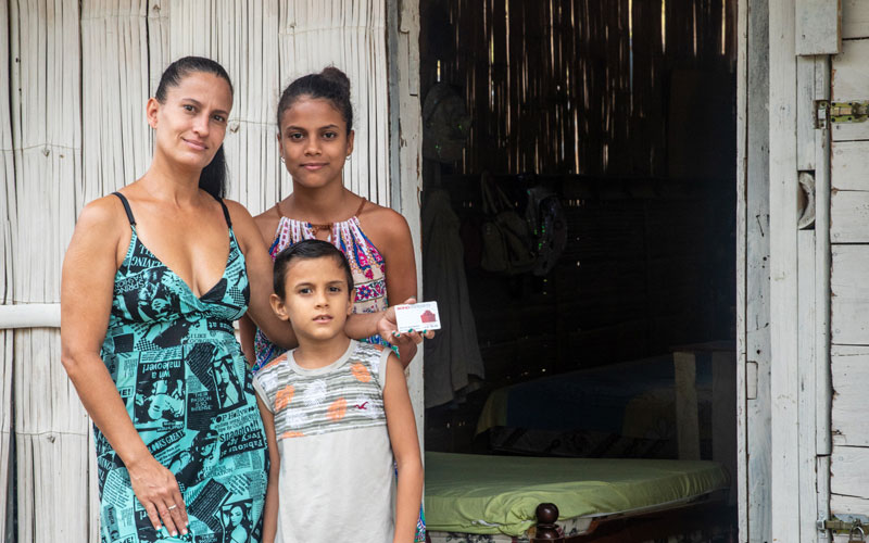 Une femme vénézuélienne se tient debout avec ses deux enfants.