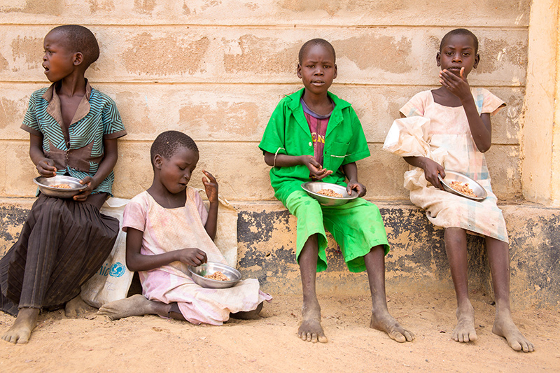 Les enfants reçoivent un repas de sorgho et de haricots à l’école.