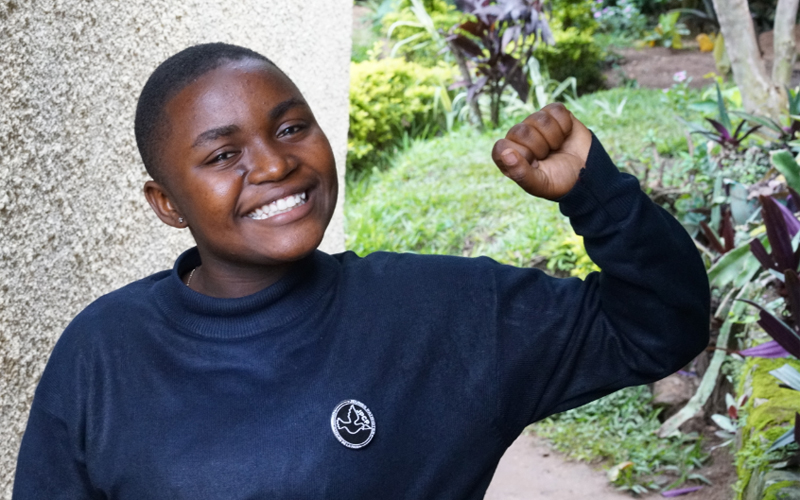 Une jeune fille de la République démocratique du Congo regarde la caméra et sourit.