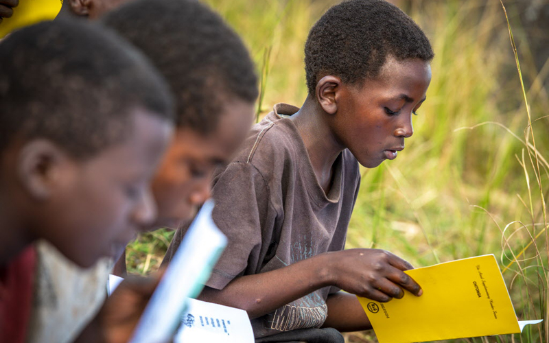 boy reads a book at reading camp