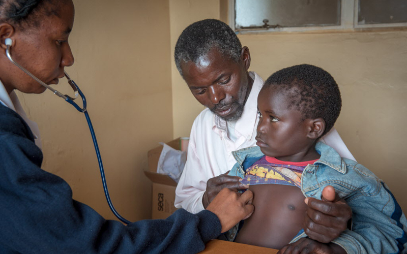 nurse examines little boy at the hospital with his dad