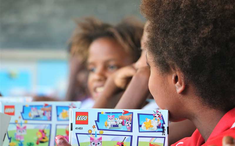 Enfant de profil tenant une boîte de jeux.