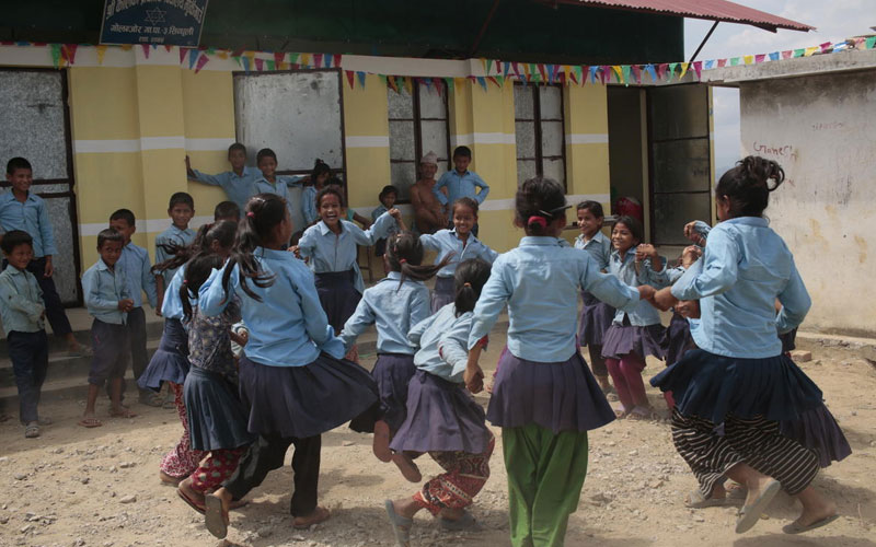 Un groupe de filles en uniformes bleus forment un cercle et jouent.