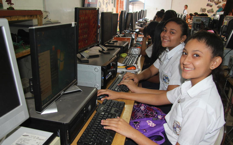 Female students inside a computer laboratory at school.Des étudiantes dans une salle informatique à l’école.