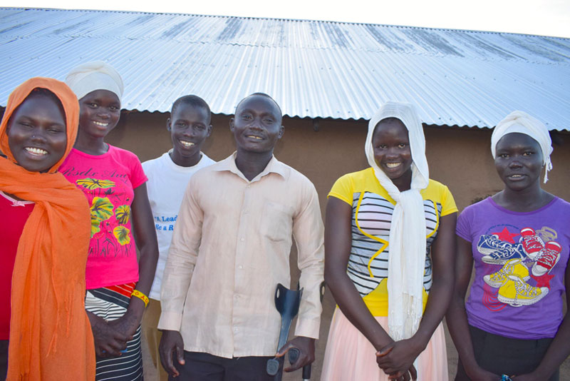 Des membres d’un centre communautaire d’enseignement de Vision Mondiale posent ensemble, le sourire aux lèvres.