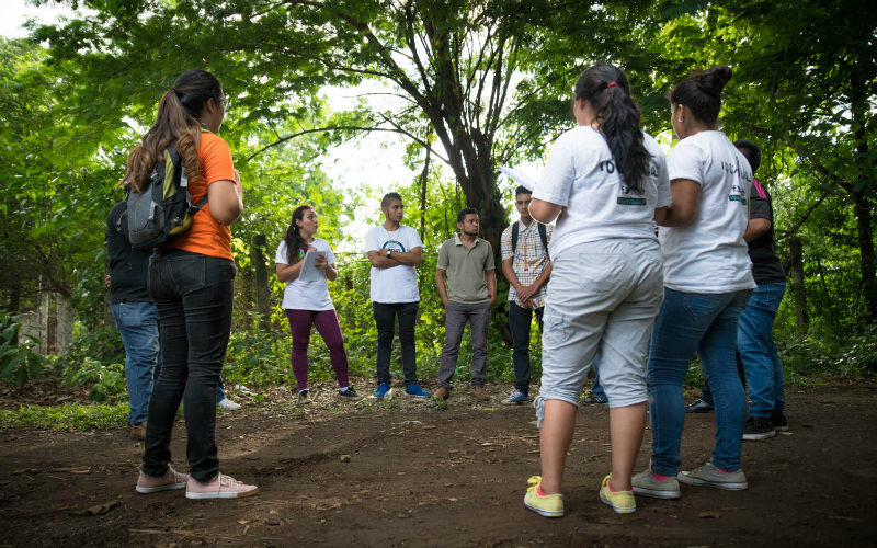 Several young people stand in a circle.